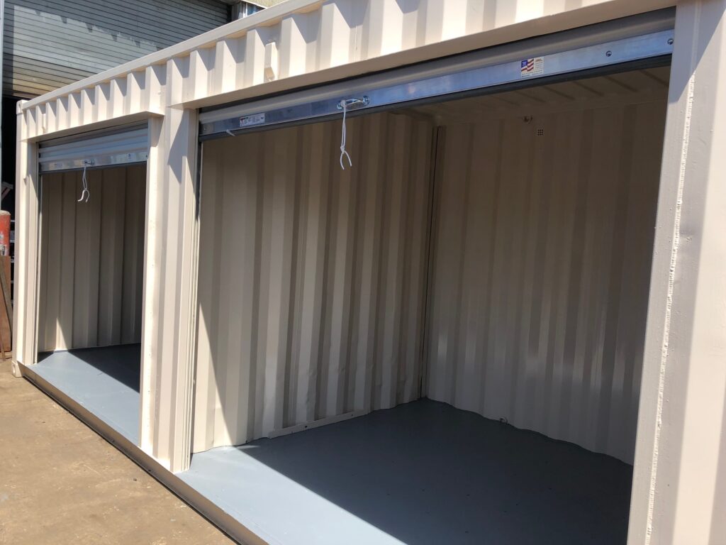 40' milvan container with several roll up doors and interior partition walls to form separate compartments (exterior -open doors)