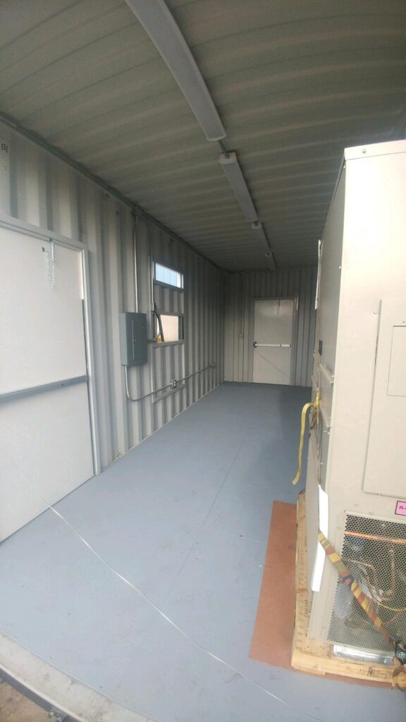 Customized cargo container with HVAC system installed on the side, shipped securely inside the container for customer installation on site. Container also has 3068 personnel doors, lighting circuit breaker panel and other electrical components (inside - back)